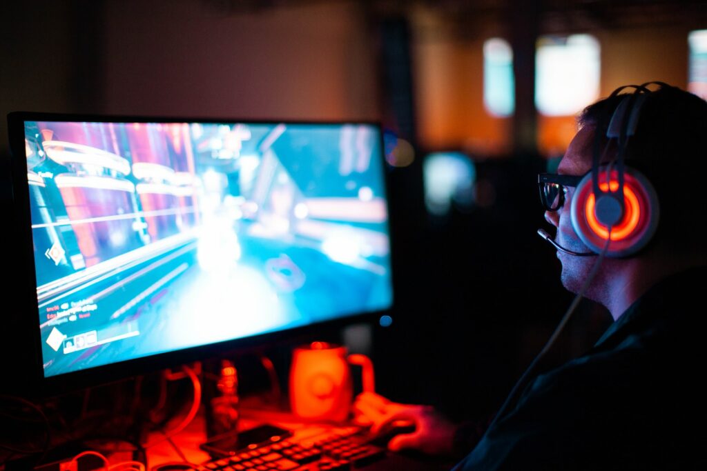 man playing computer with headphones